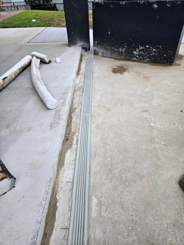 Expansion-joint profile at an exterior concrete surface and wall return"