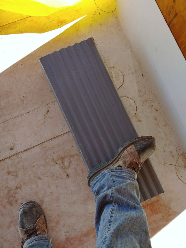 Ribbed expansion-joint cover component beside an interior floor opening"