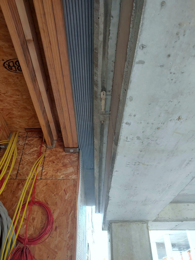 Expansion-joint detail beside exposed wall framing"
