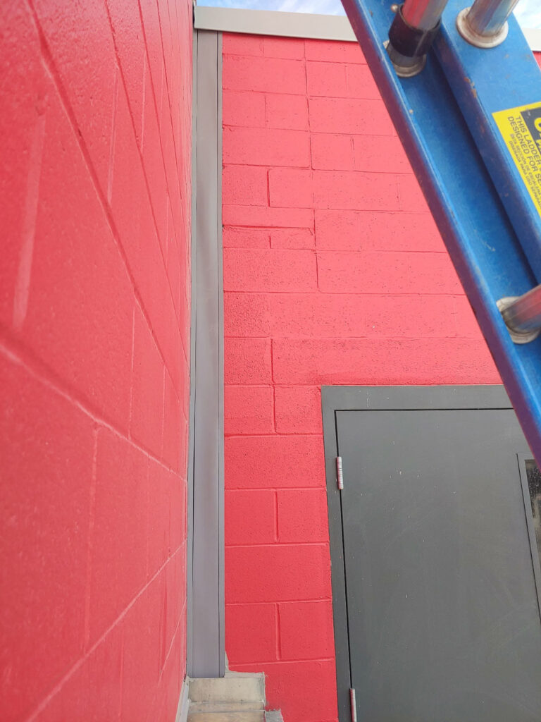 Exterior commercial caulking at joints adjacent to stone masonry.