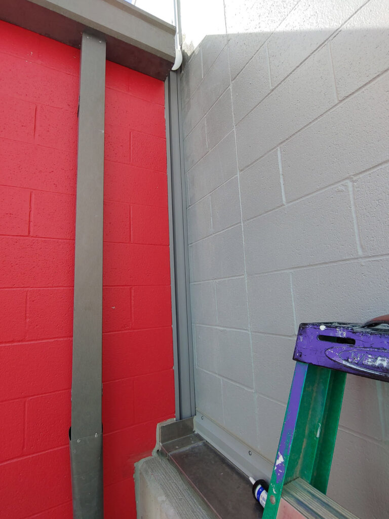 Wall-joint transition between red and gray blockwork"