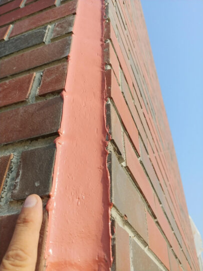 Close view of a sealed vertical caulking joint at a brick corner. Building Envelope Process