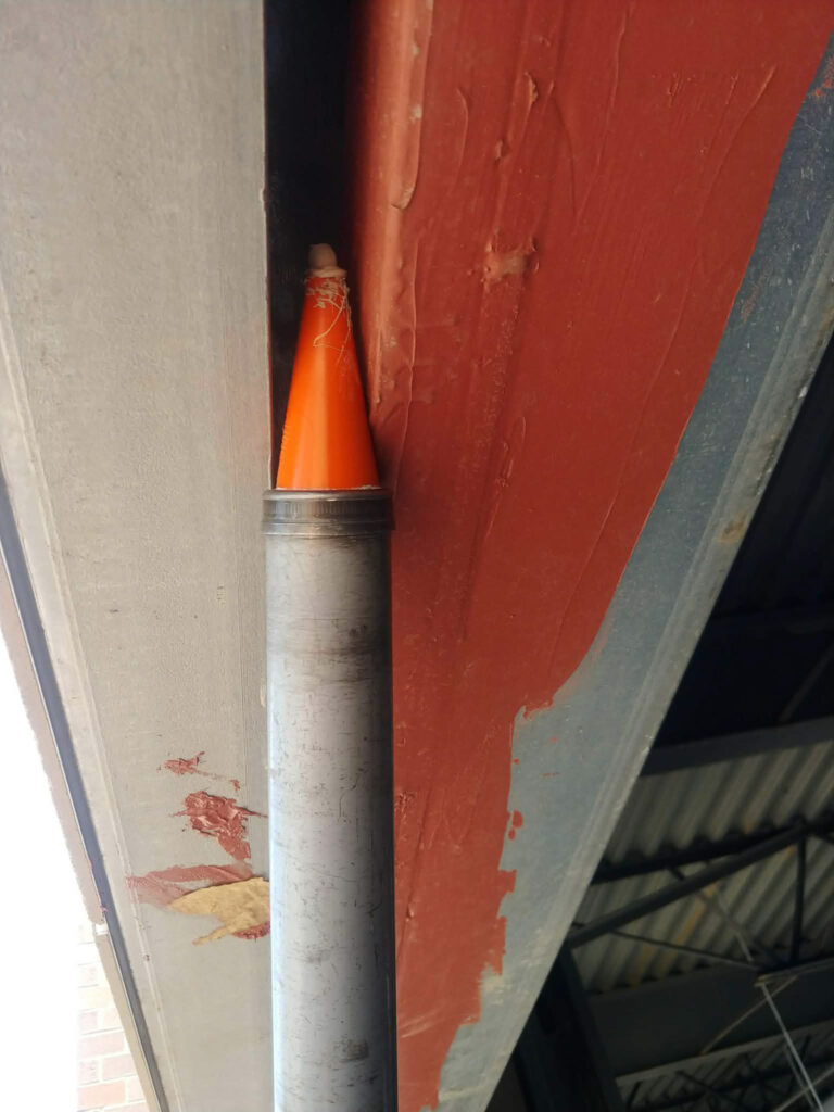 Caulking gun beside a frame and wall joint"