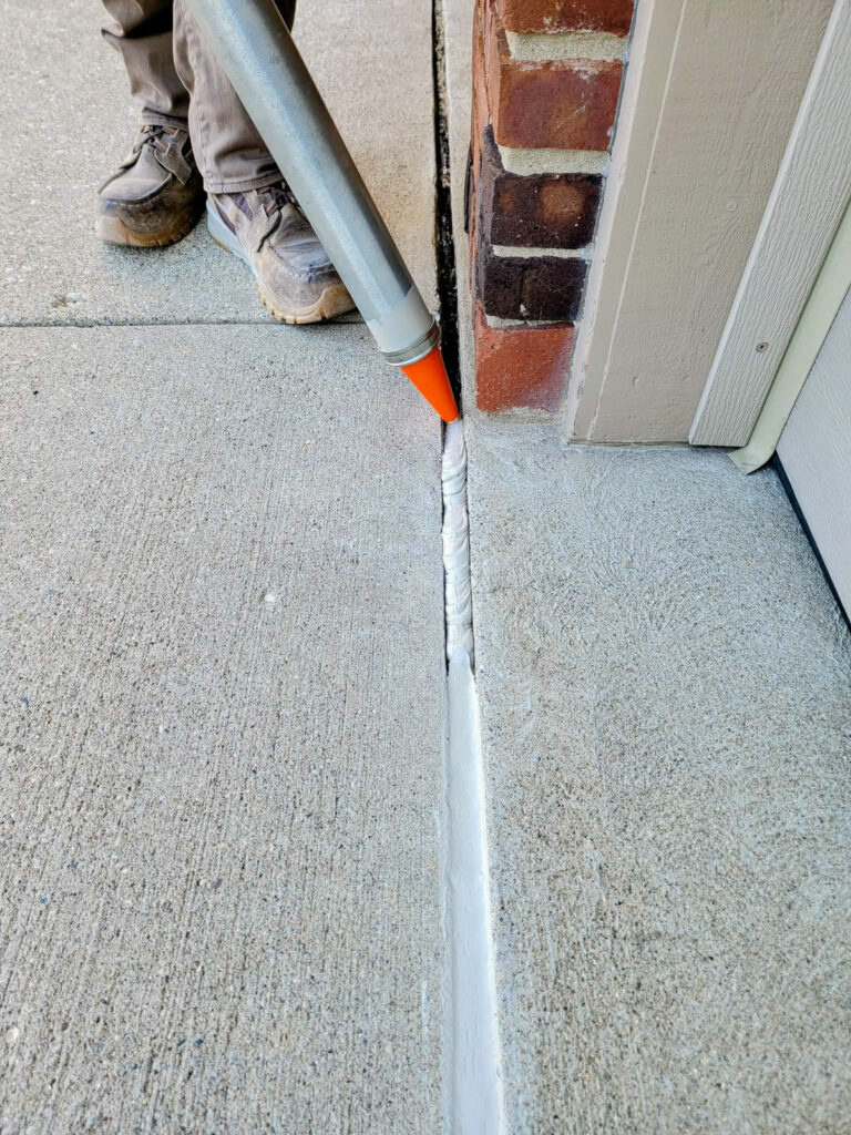 Sealant at a concrete threshold and wall joint"