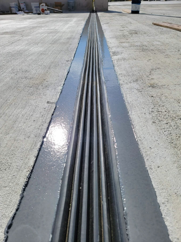Expansion-joint channel between adjacent concrete deck areas"