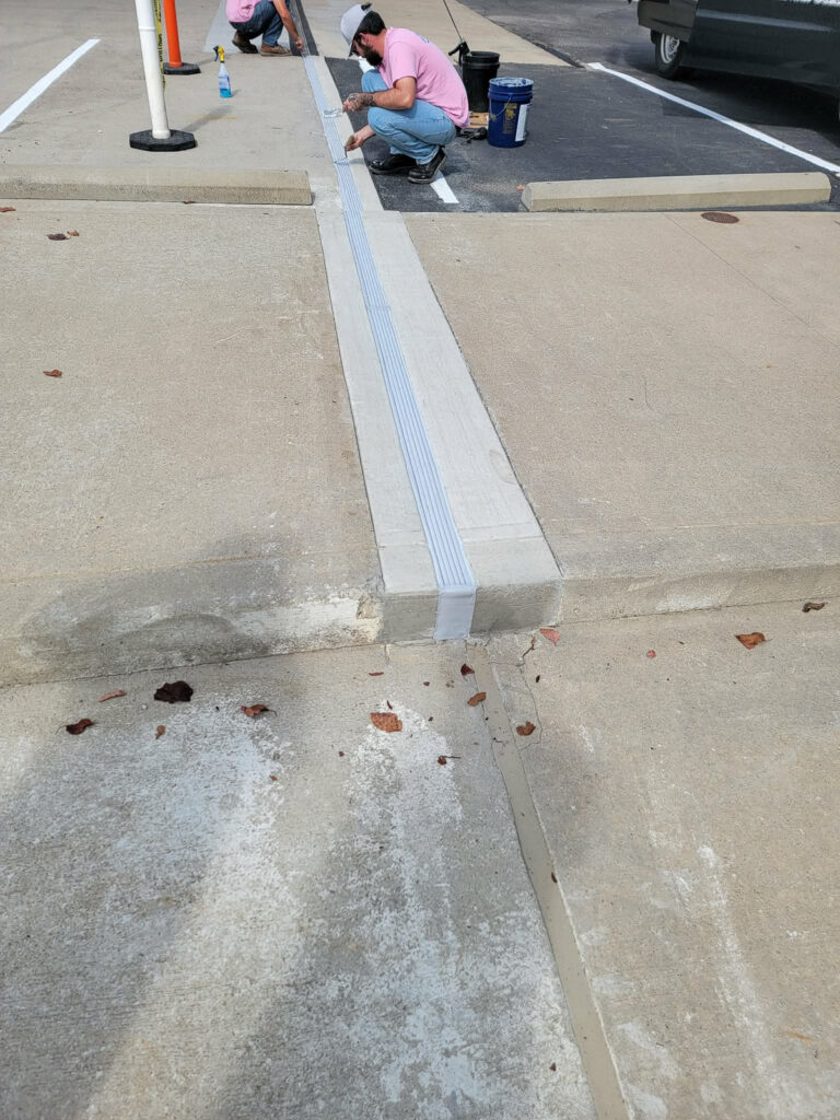 Crew working beside a concrete deck joint cover"