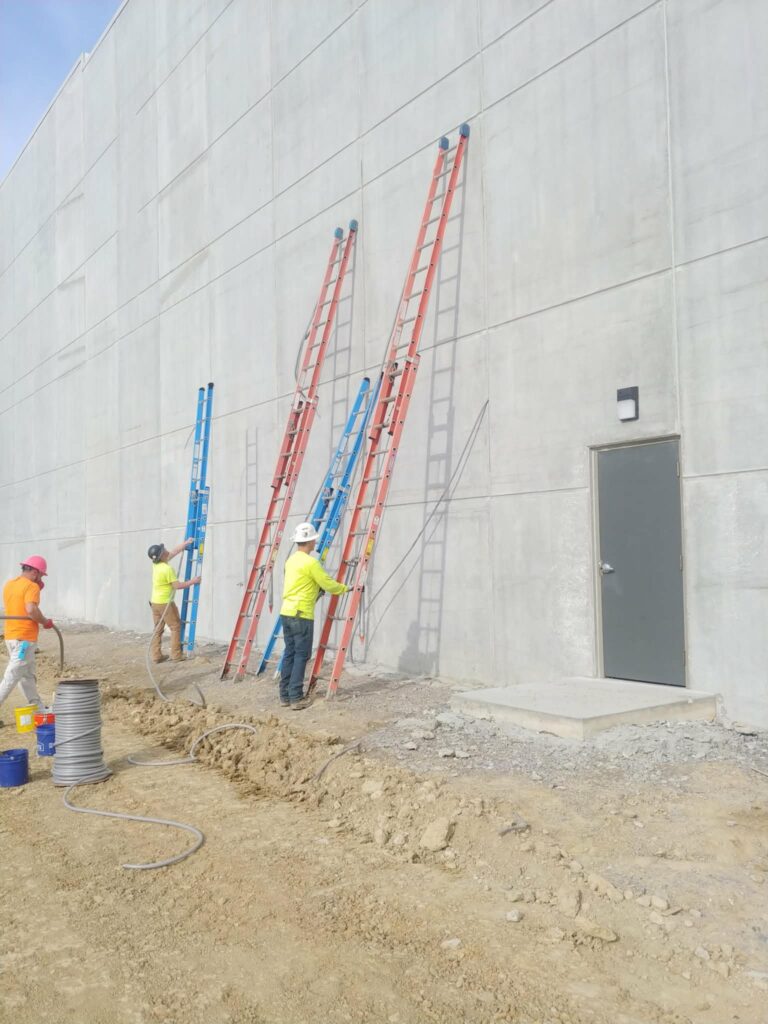 Crew working along commercial concrete wall joints"