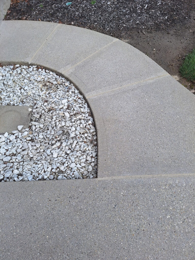 AFTER - Finished concrete joint sealant along a residential garage driveway entrance."