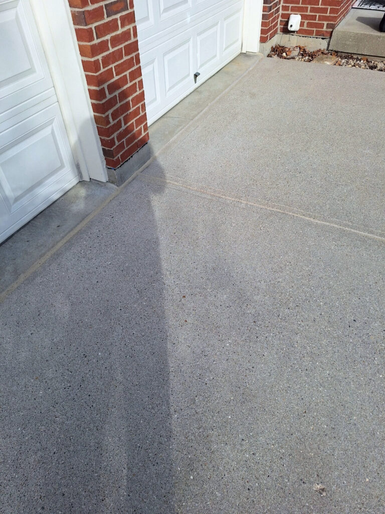 AFTER - Finished concrete joint sealant along a residential garage driveway entrance."