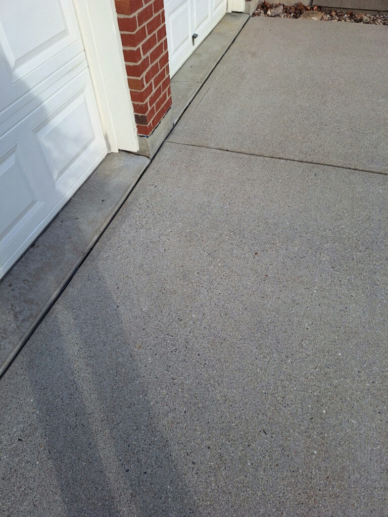BEFORE Finishing concrete joint sealant & driveway cleaning.  For a residential garage driveway entrance."